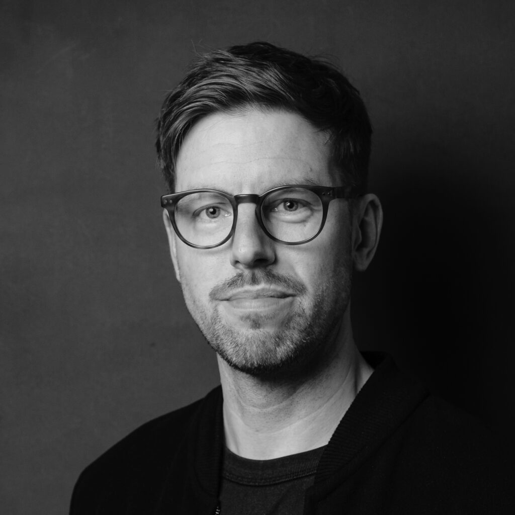 Picture of Juha Pera: Man with wire classes, short dark hair, neatly trimmed mustache